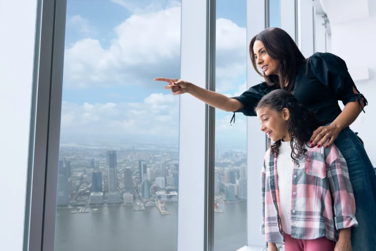Mother and daughter looking at view from One World Observatory during 9/11 Guided tour