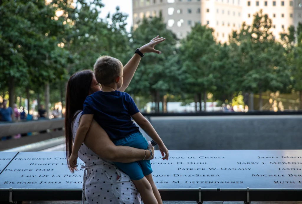 Mother holding child at Ground Zero memorial_Credit line Courtesy of Jin Lee, 911 Memorial & Museum