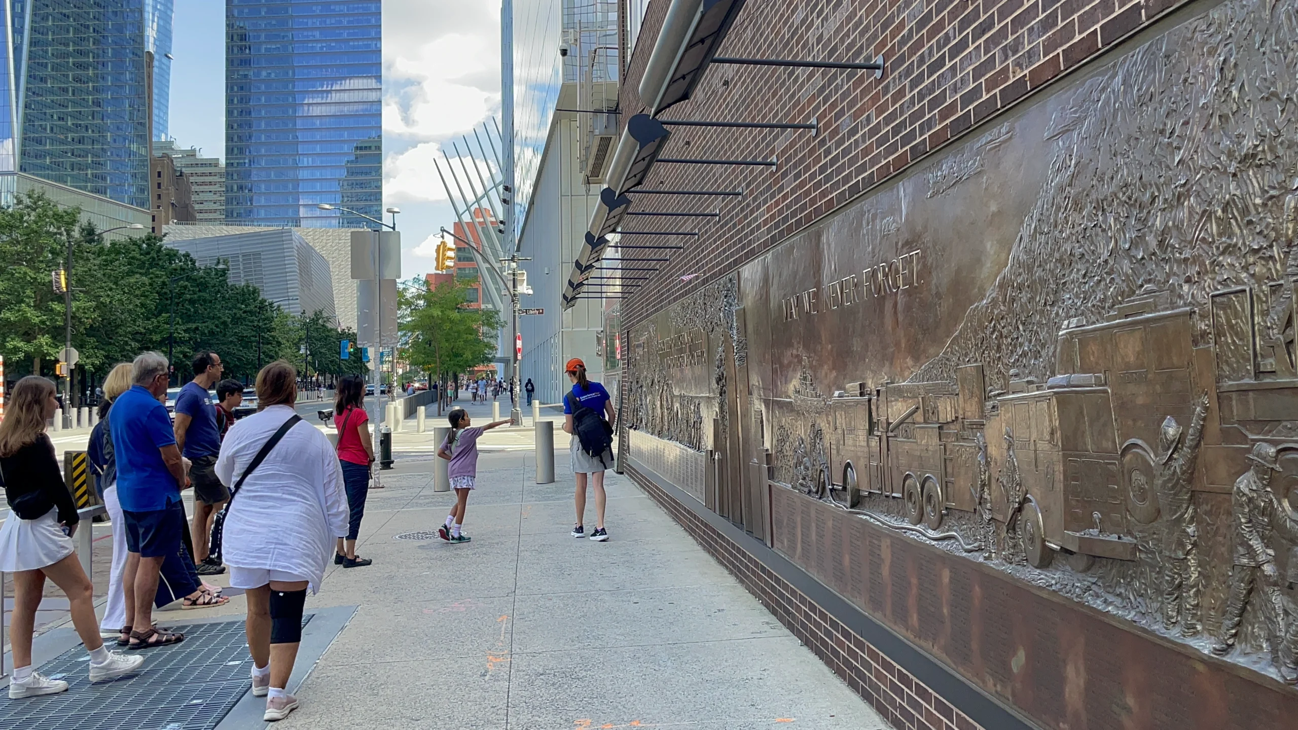 People walking past Firefighter Memorial during 9/11 Ground Zero guided tour