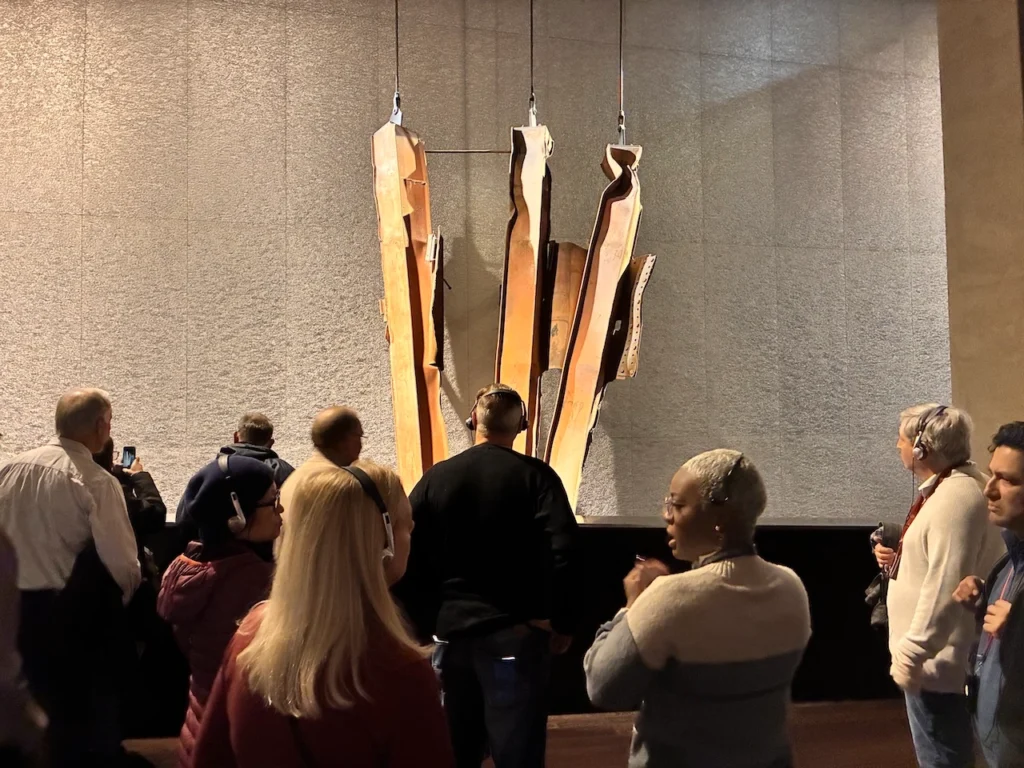 Visitors looking at the trident beam in the 911 Museum
